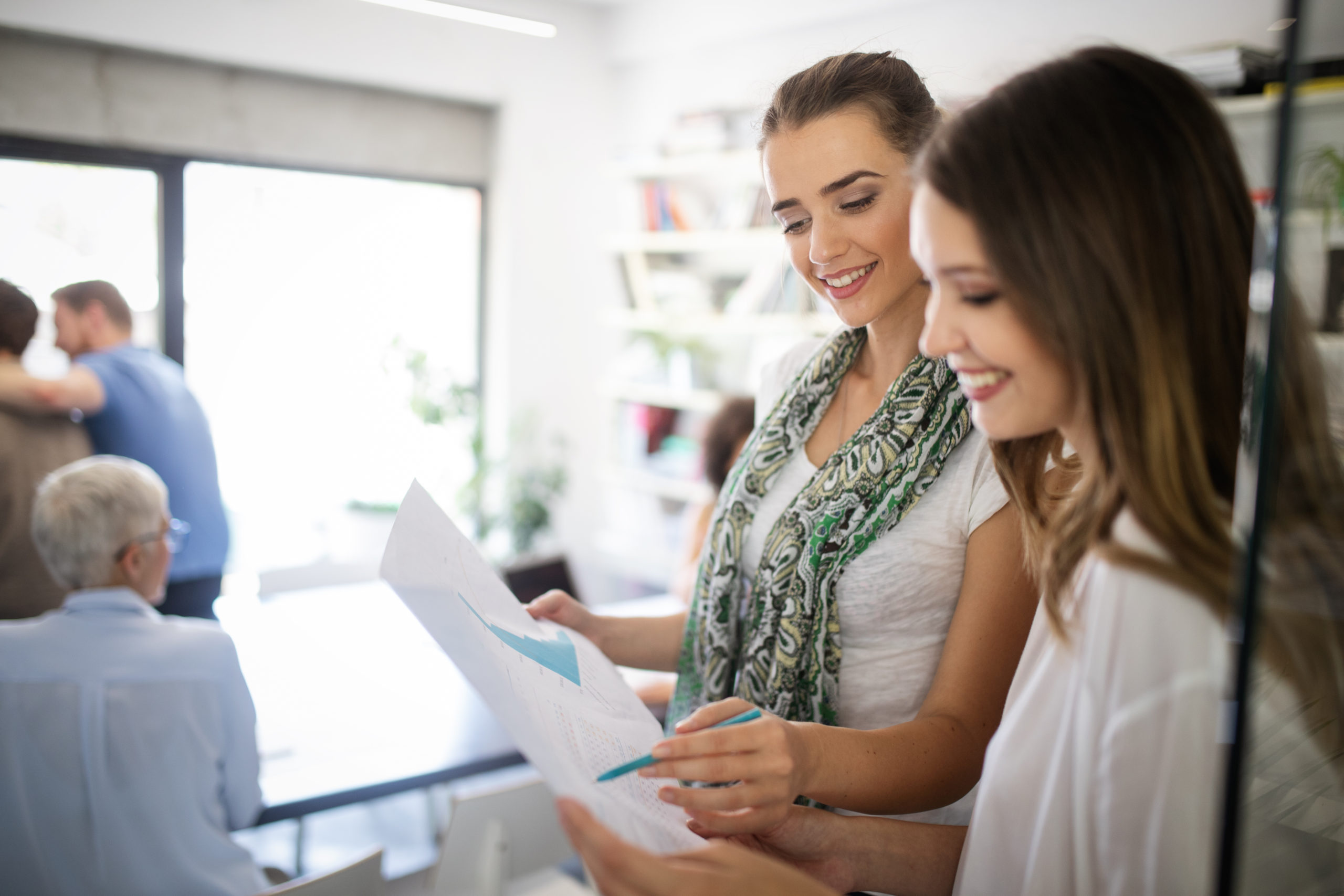 Woman consultant reviewing change management plan with female client in a casual business setting