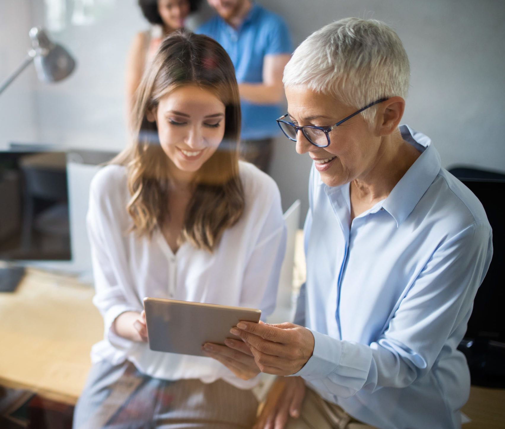 Woman consultant reviewing data on a tablet with female client in an office