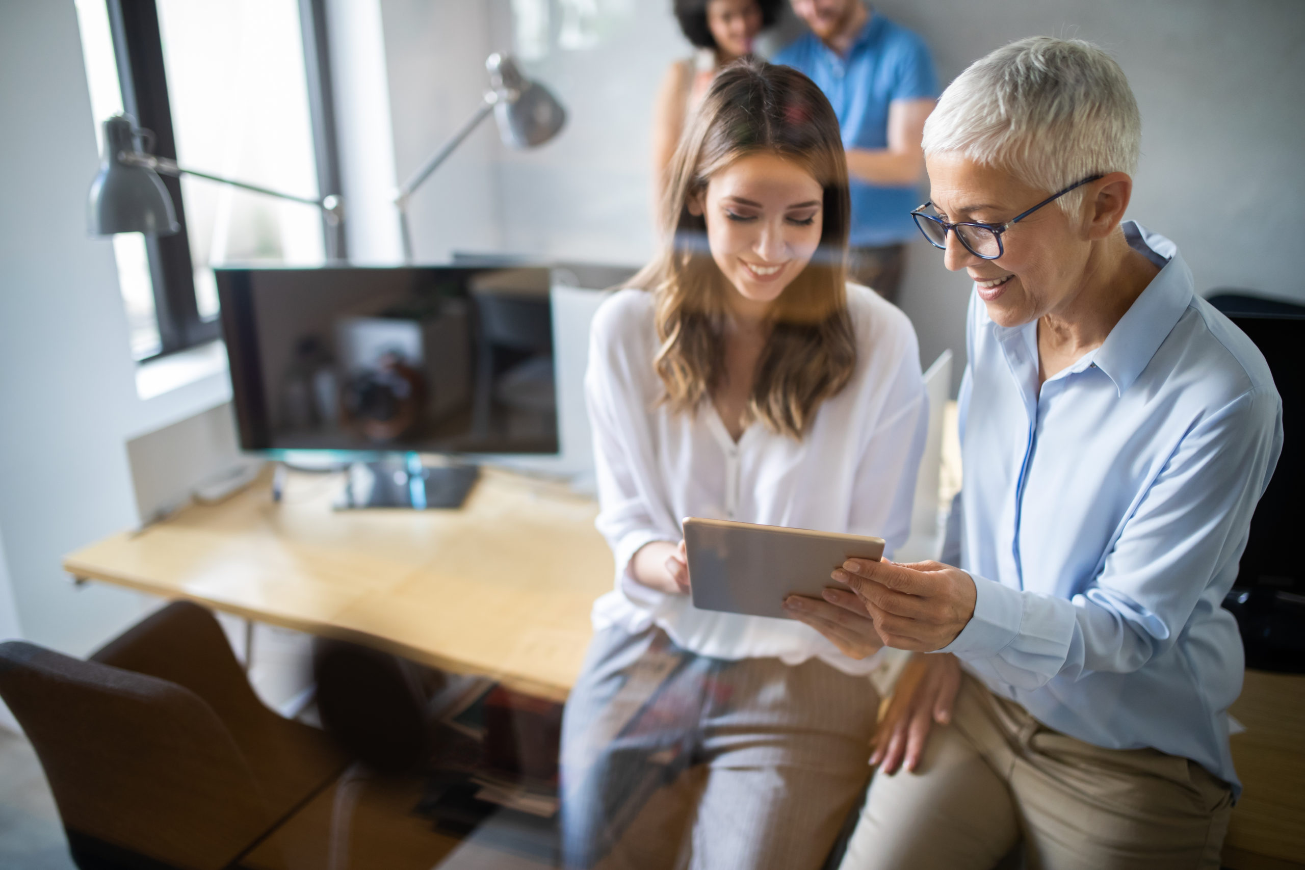 Woman consultant reviewing data on a tablet with female client in an office