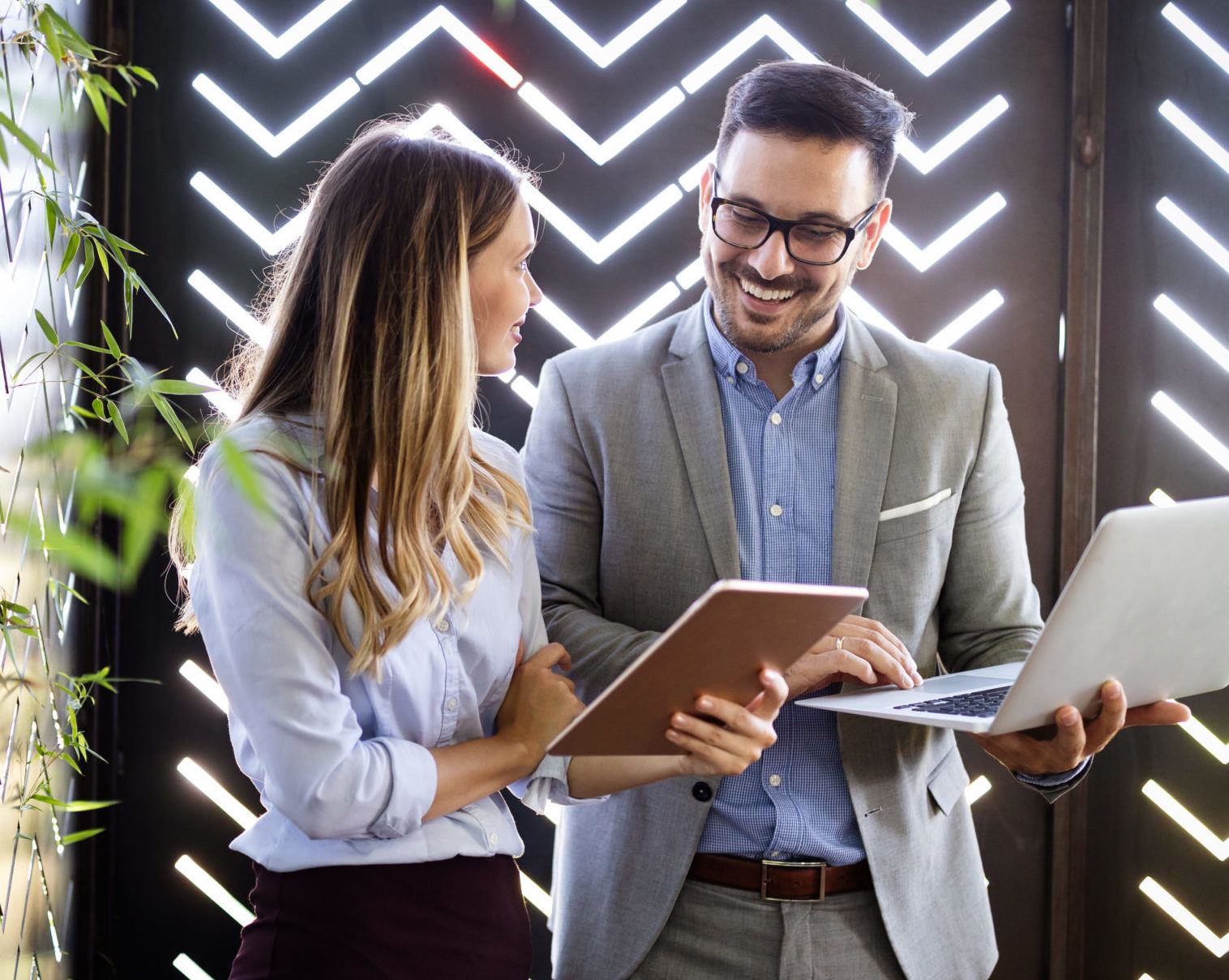 Woman consultant talking with a male client while standing in a casual business setting